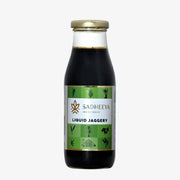Sadheeya liquid jaggery in a glass bottle with a gold cap and green label, isolated on a white background.